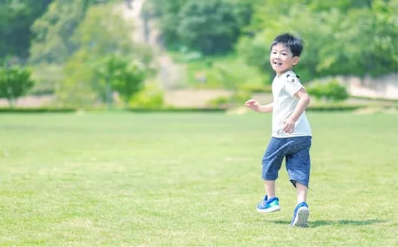 芝生の広場を笑顔で走る男の子