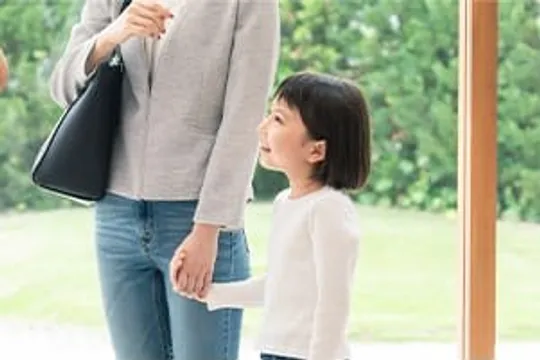大人と手をつなぎ見上げる女の子