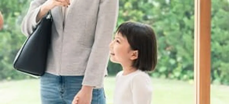 大人と手をつなぎ見上げる女の子